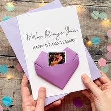 Load image into Gallery viewer, A hand holding a handmade card with a photo of a couple inside a heart-shaped origami. The card is purple and white, and the message reads "It Was Always You" and "Happy 1st Anniversary".