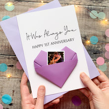 Load image into Gallery viewer, A hand holding a handmade card with a photo of a couple inside a heart-shaped origami. The card is purple and white, and the message reads "It Was Always You" and "Happy 1st Anniversary".