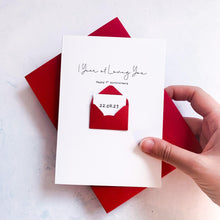 Load image into Gallery viewer, A hand is holding a card with a message and a small envelope on top of it, against a white background.